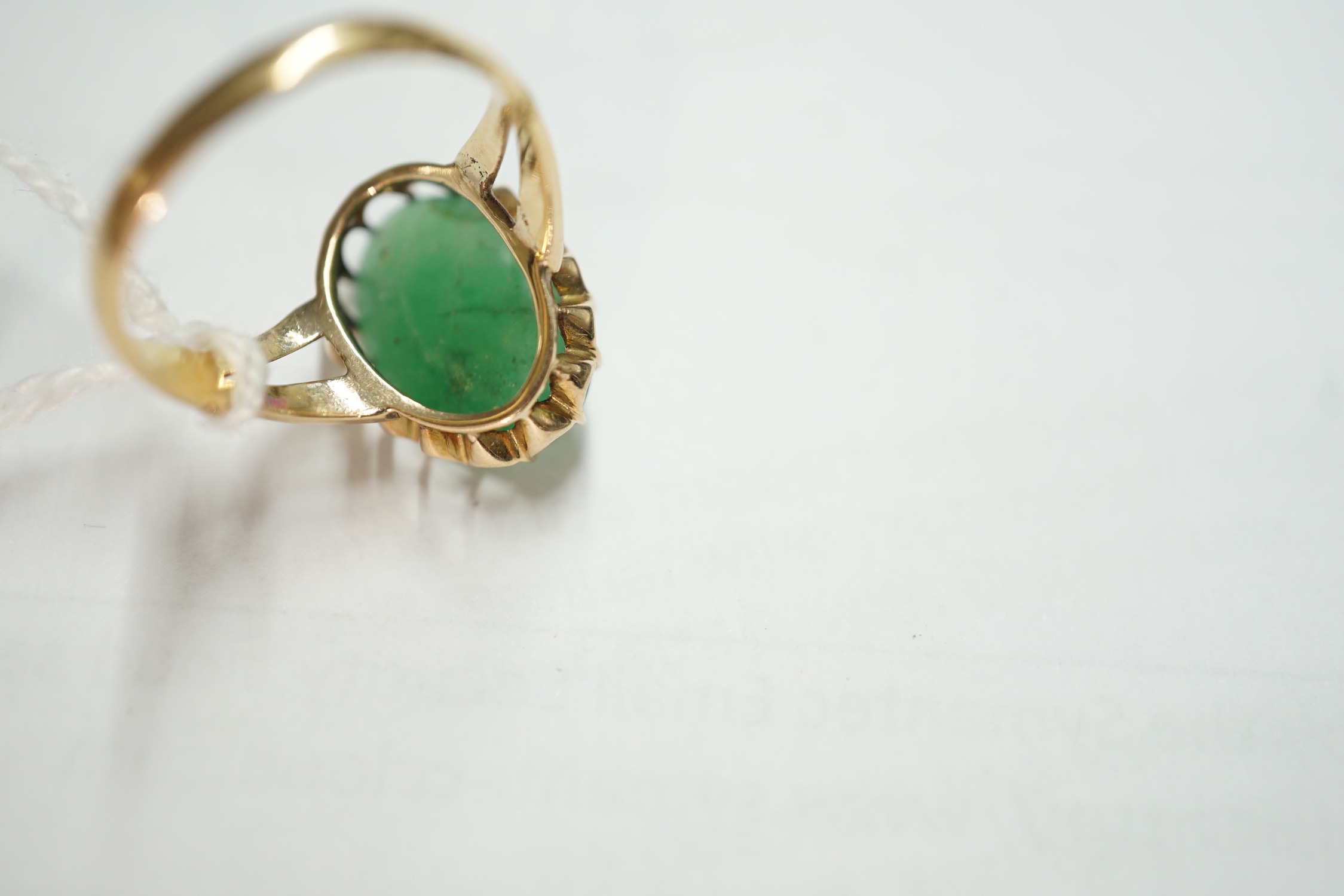 A Chinese yellow metal and cabochon jade set oval ring, size Q/R, gross weight 5 grams.